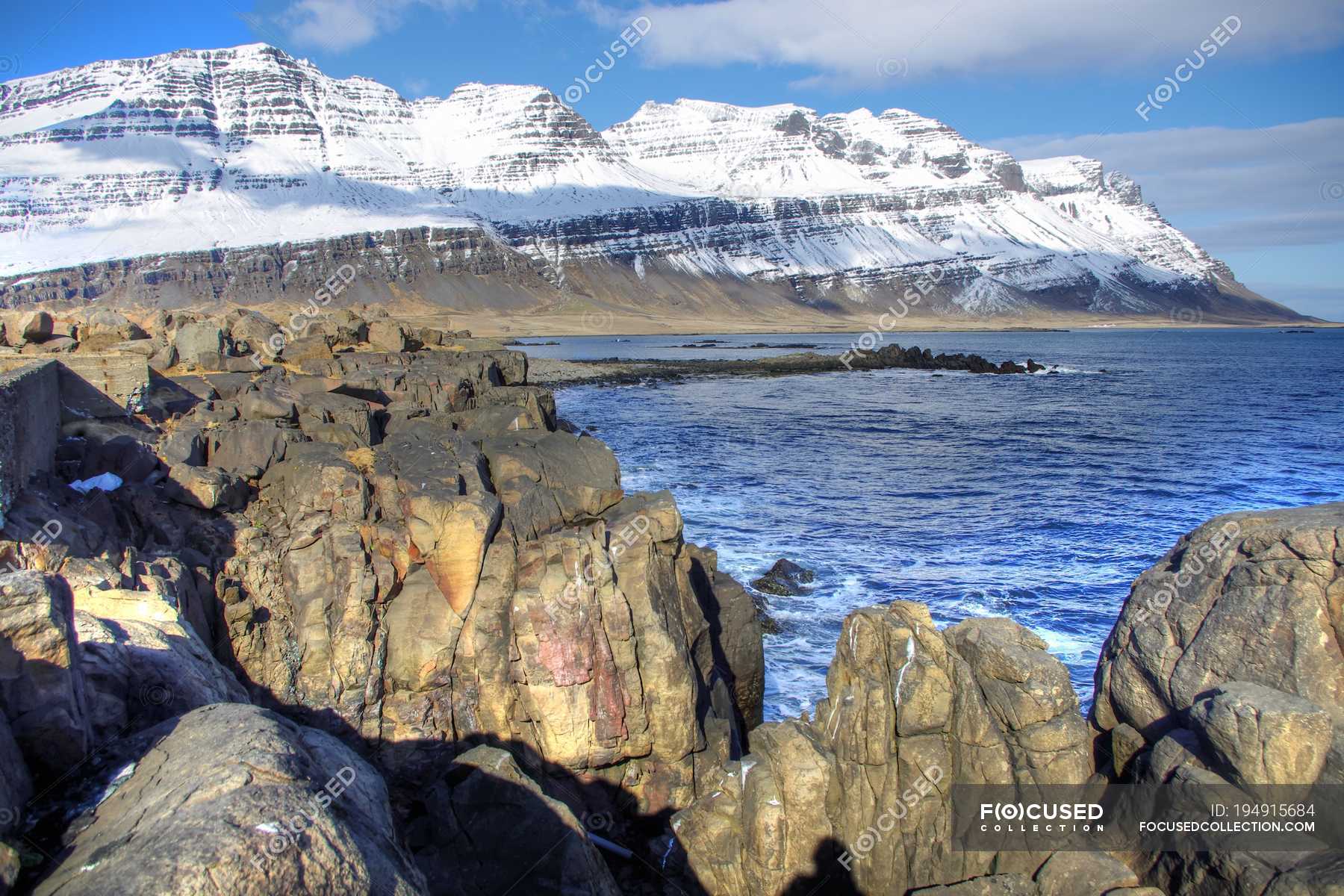 Snowy Mountain With Gigantic Rocks In Foreground Iceland Background Idyllic Stock Photo