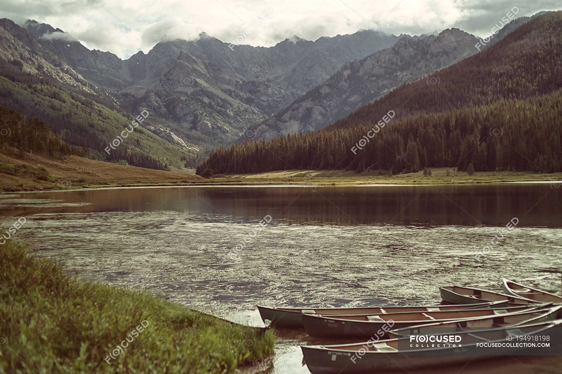 USA, Colorado, Vail, Piney Lake, Empty kayaks next to lakeshore with ...