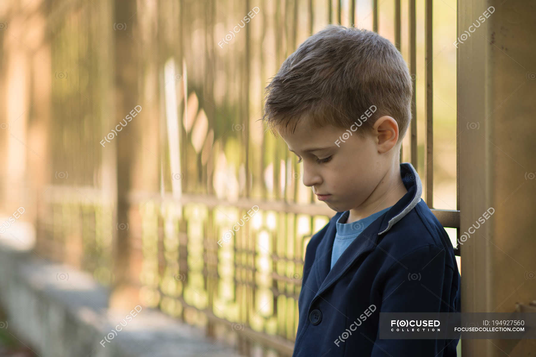 Portrait of sad boy leaning on fence — kid, daytime - Stock Photo ...