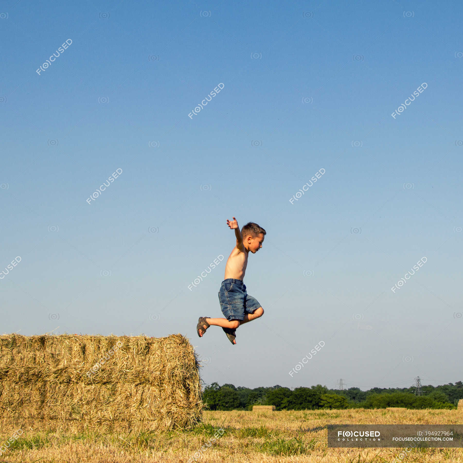 boy-jumping-off-hay-bale-in-countryside-innocence-agriculture