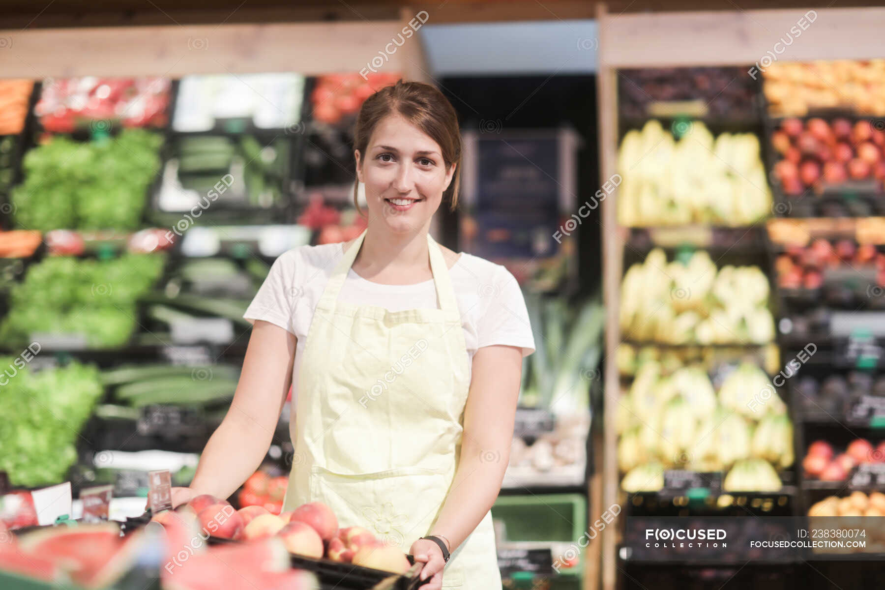 Porträt einer lächelnden Verkäuferin im Obst und Gemüsebereich