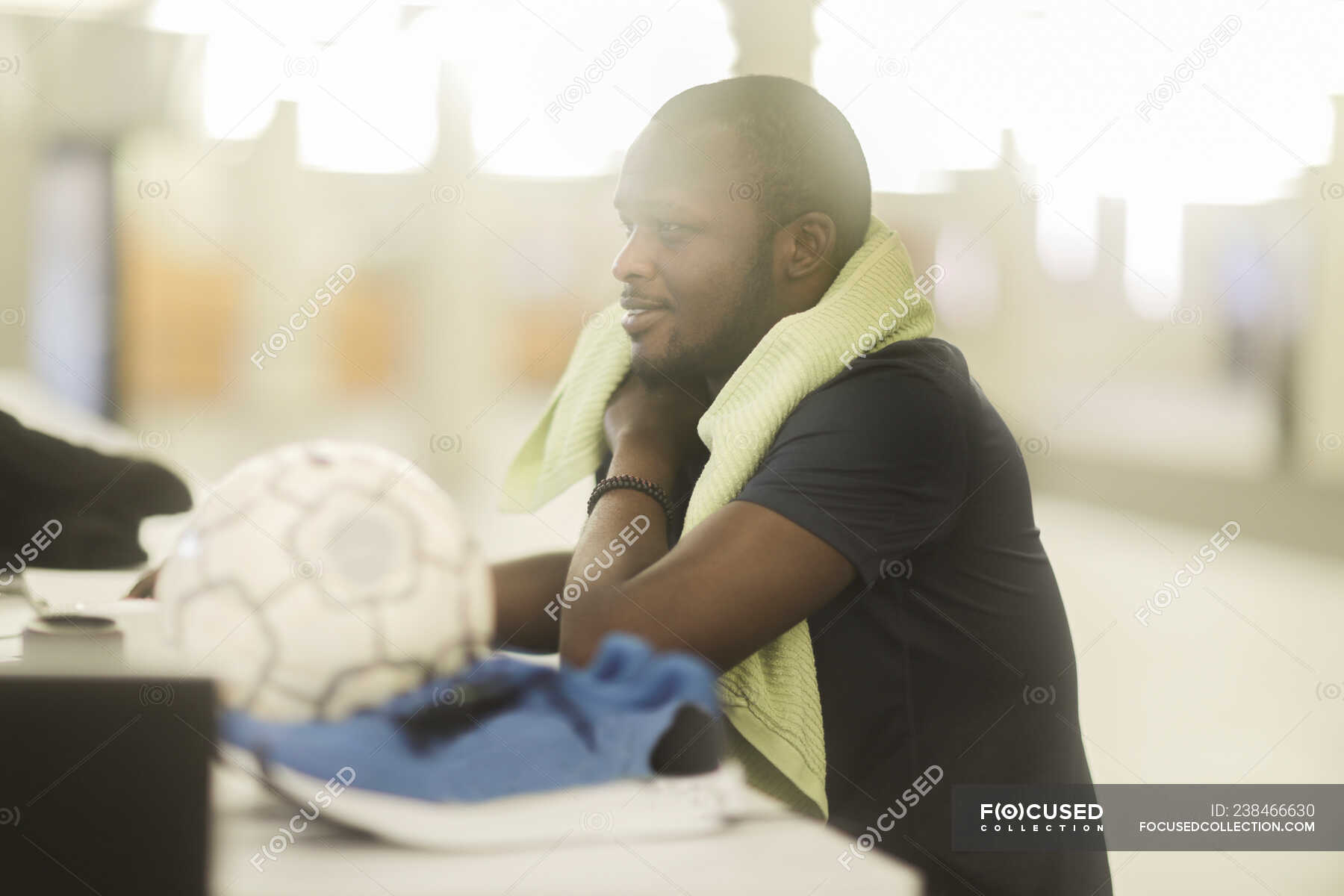 Man sitting at a desk with a football and trainers next to him — sport ...