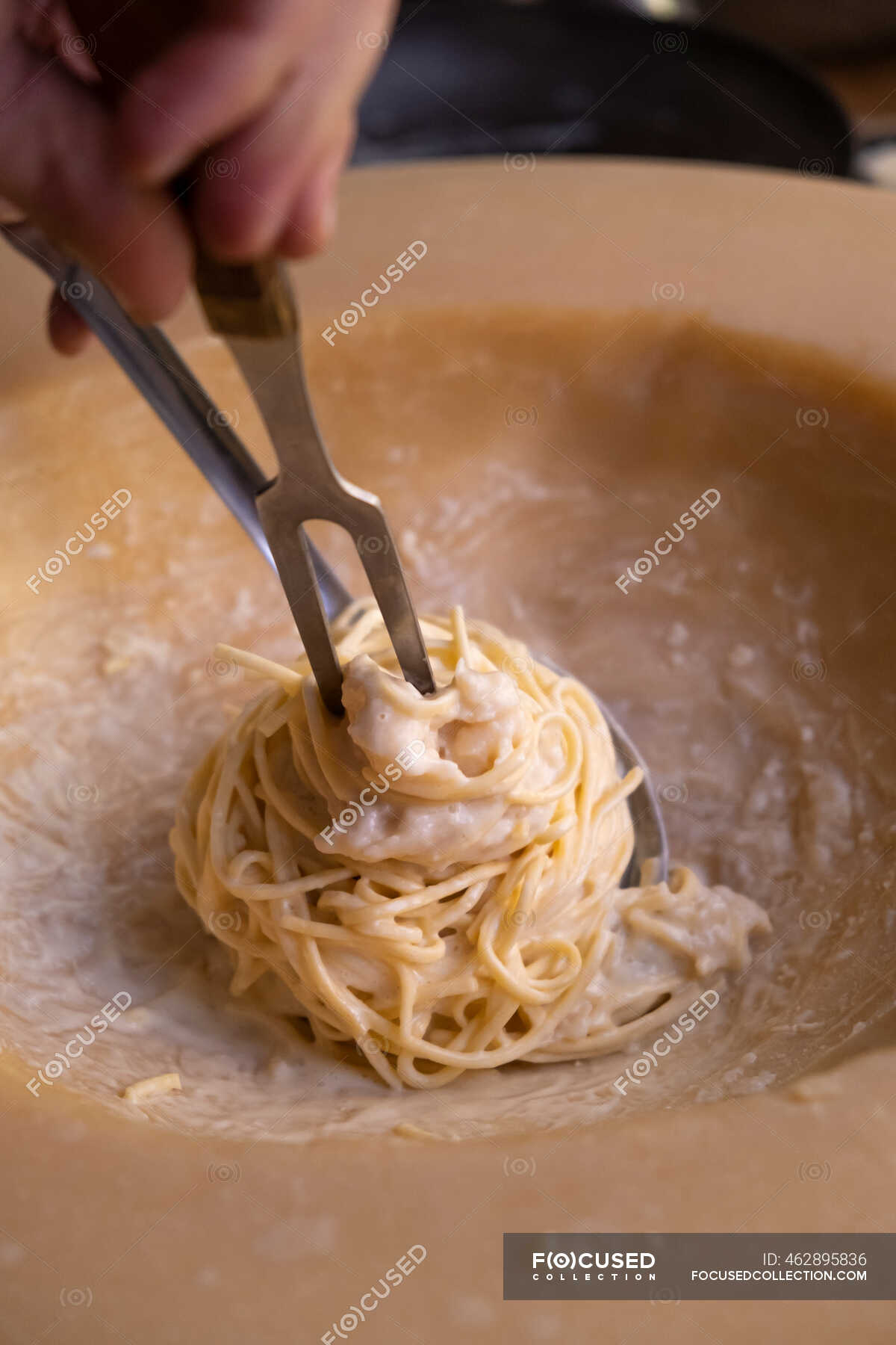 Man preparing pasta in a padano grana cheese wheel — Men, preparing food -  Stock Photo | #462895836