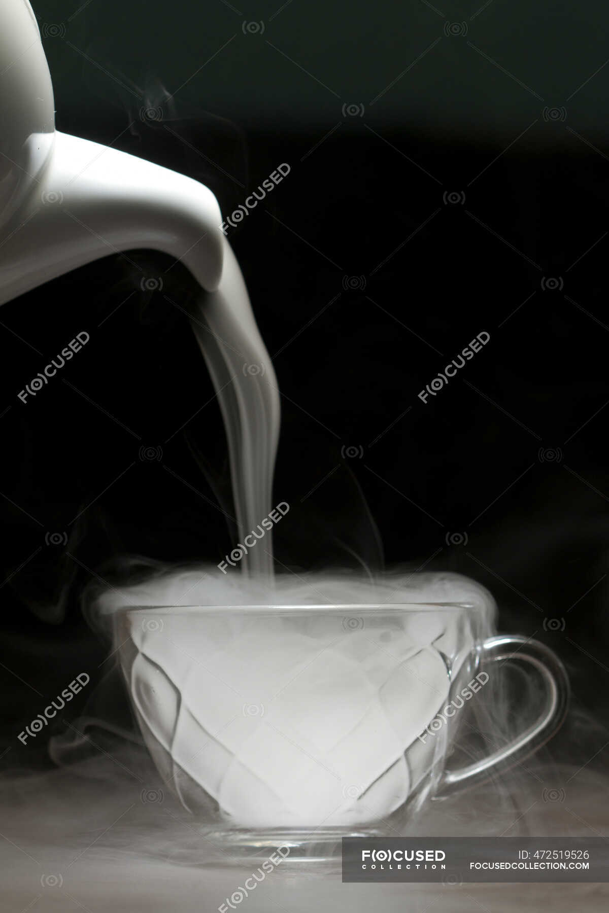 Steam being poured out of a teapot into a teacup — concepts, heat