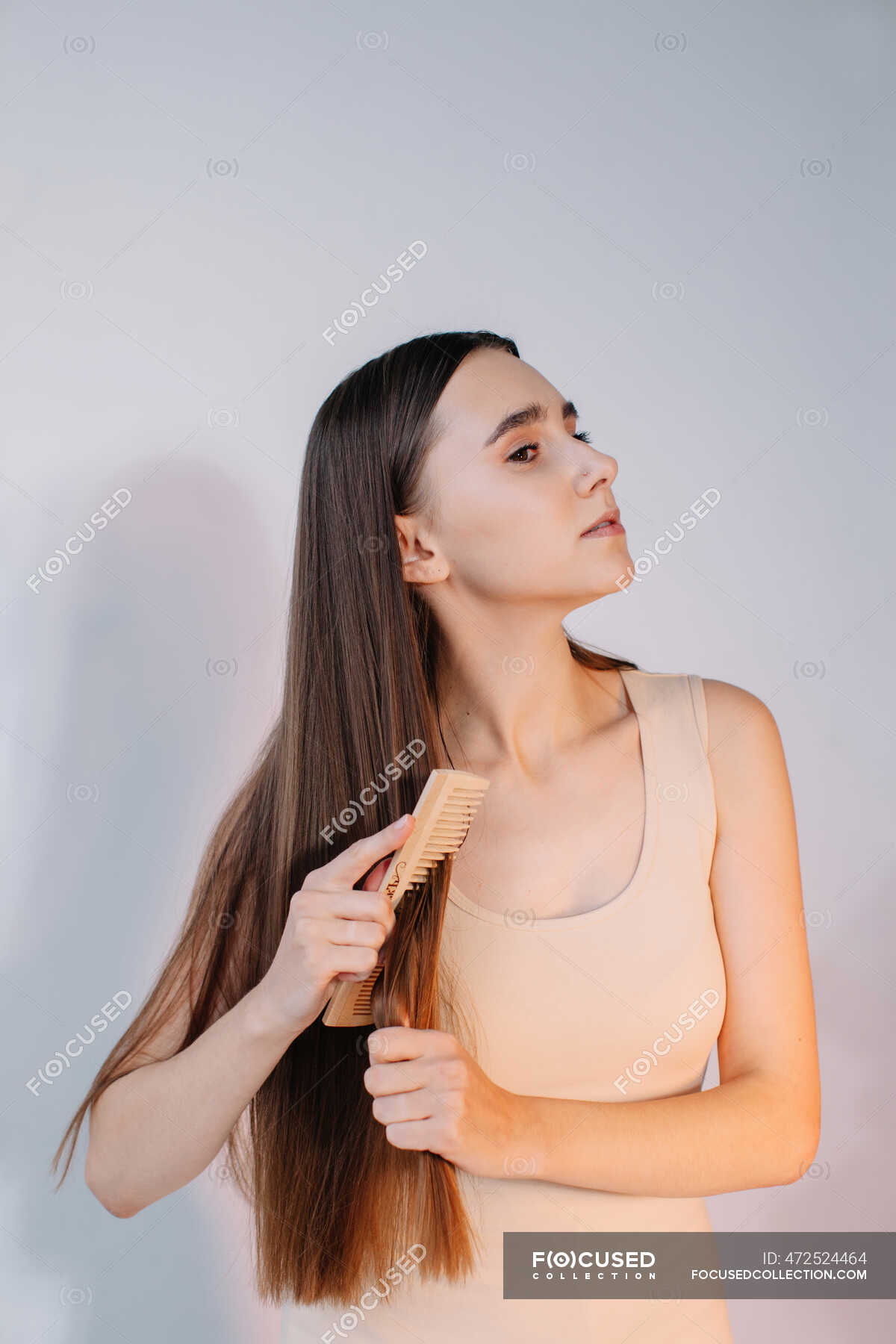 Woman combing her long hair — people, caucasian ethnicity - Stock Photo |  #472524464