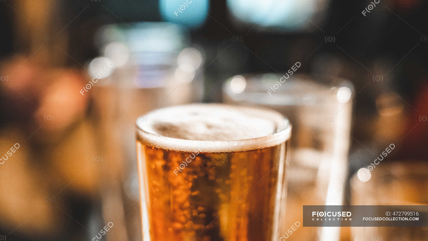 Close up of a pint of beer and empty glasses on a table — Drinking ...