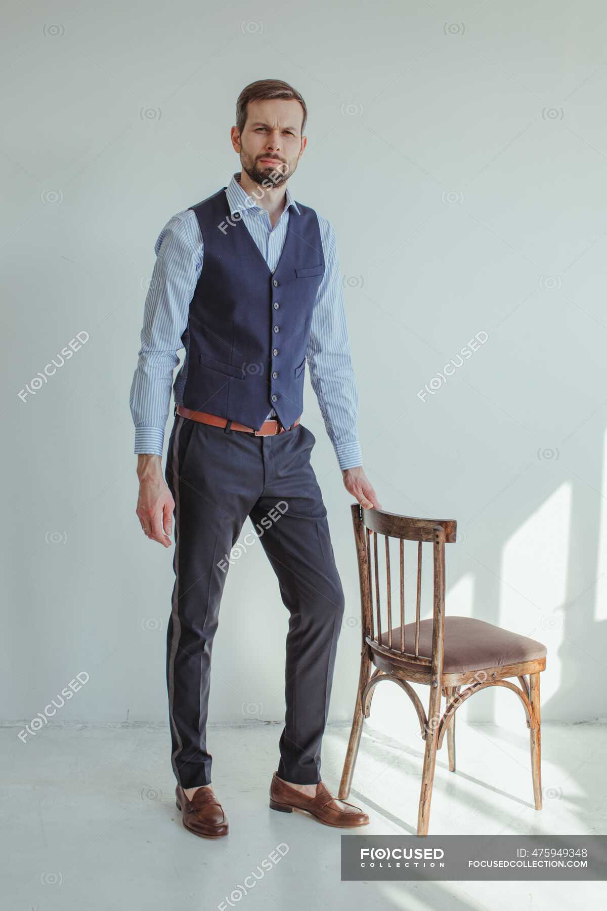 Man wearing formal clothes posing with chair in studio — view, shirt ...