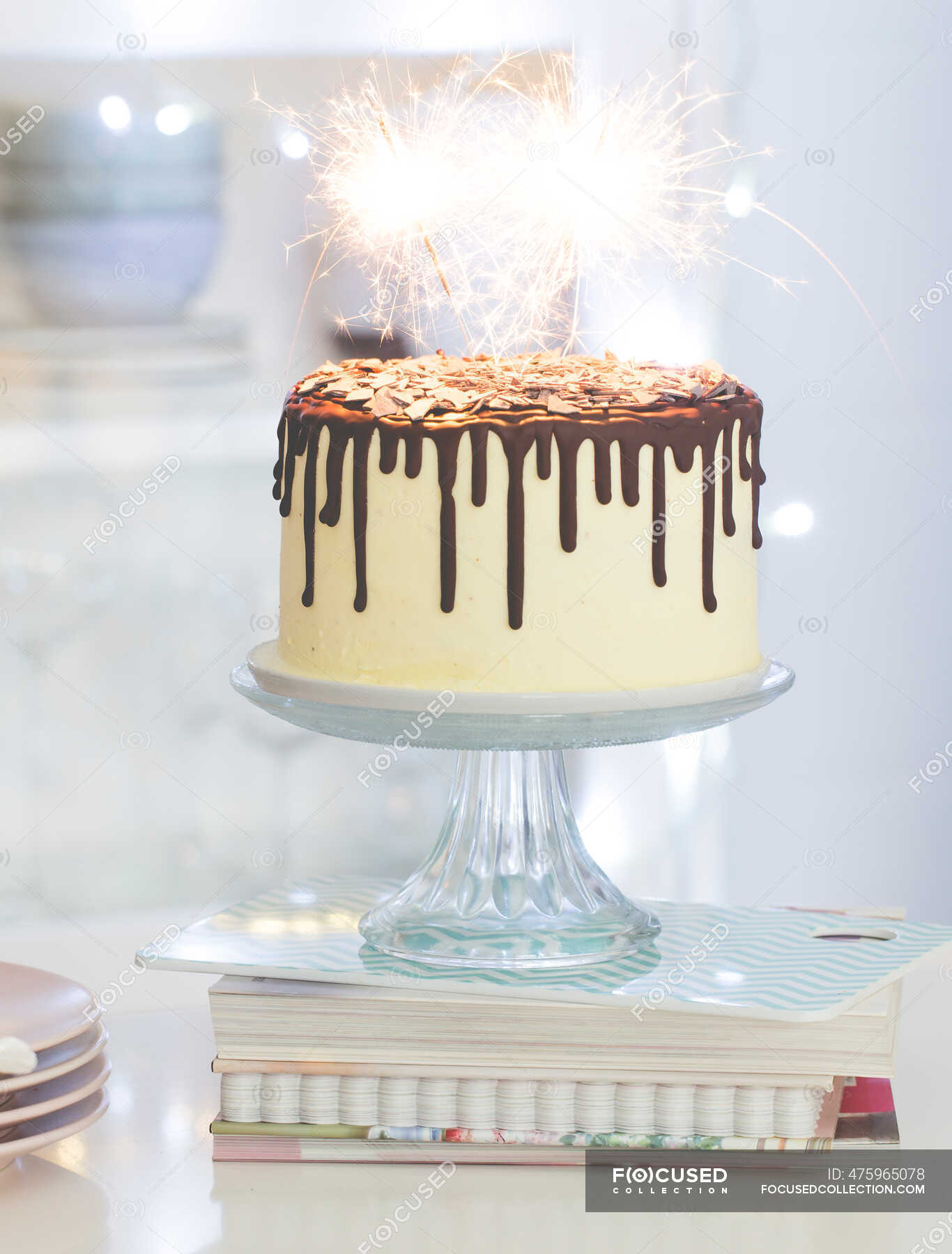 Tarta de cumpleaños de vainilla con ganache de chocolate, glaseado y chispas  en un puesto de pastel en una cocina — vertical, Alimento poco saludable -  Stock Photo | #475965078