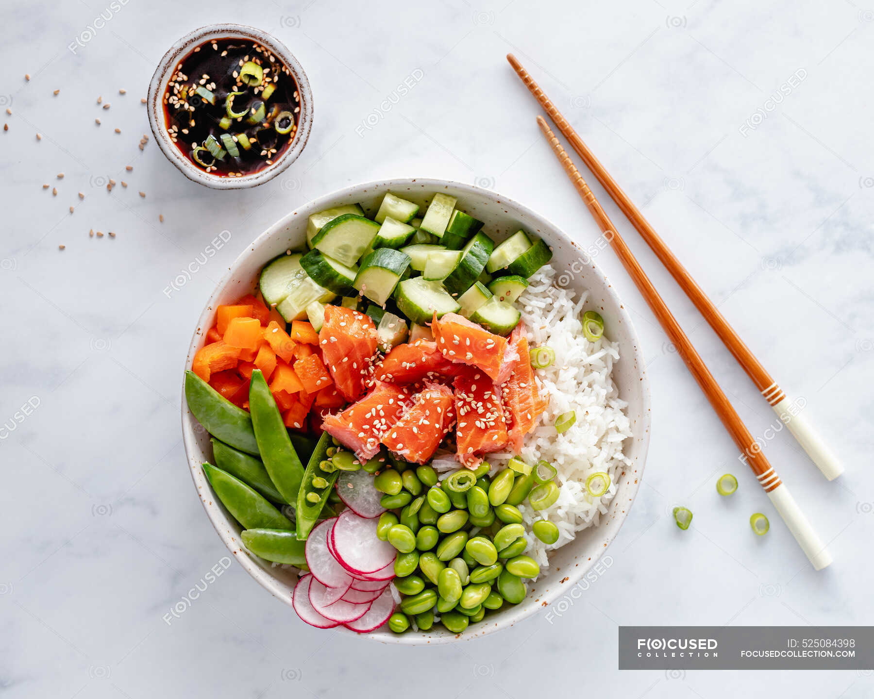 Salmon poke bowl with rice, edamame beans, cucumber, radish, mange tout