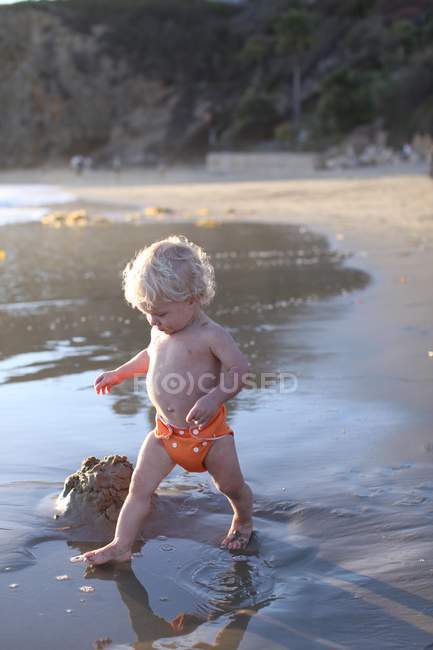 Toddler boy walking on sandy beach — Stock Photo