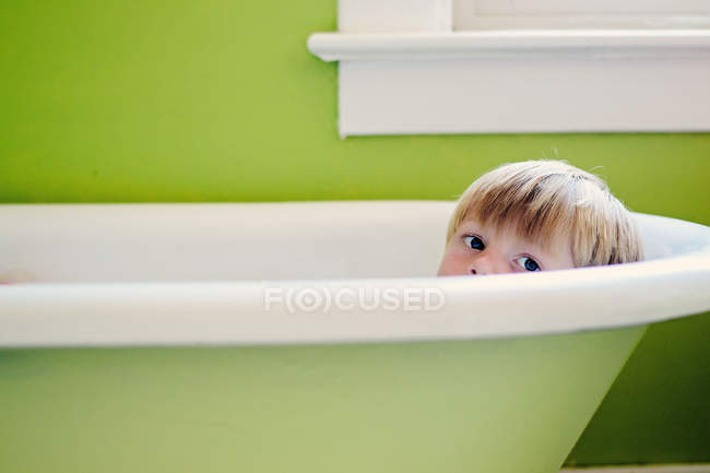 Niño sentado en el baño - foto de stock