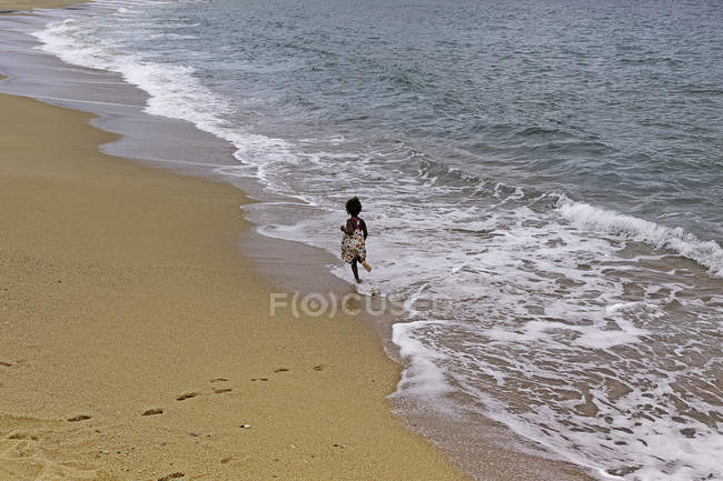 Дівчина біжить на пляжі — стокове фото