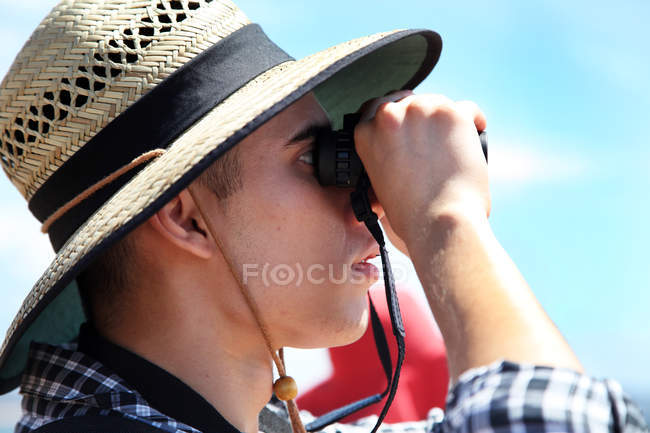 Man looking through binoculars — Stock Photo