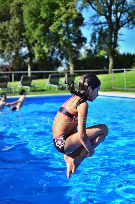 Fille sauter dans la piscine — Photo de stock