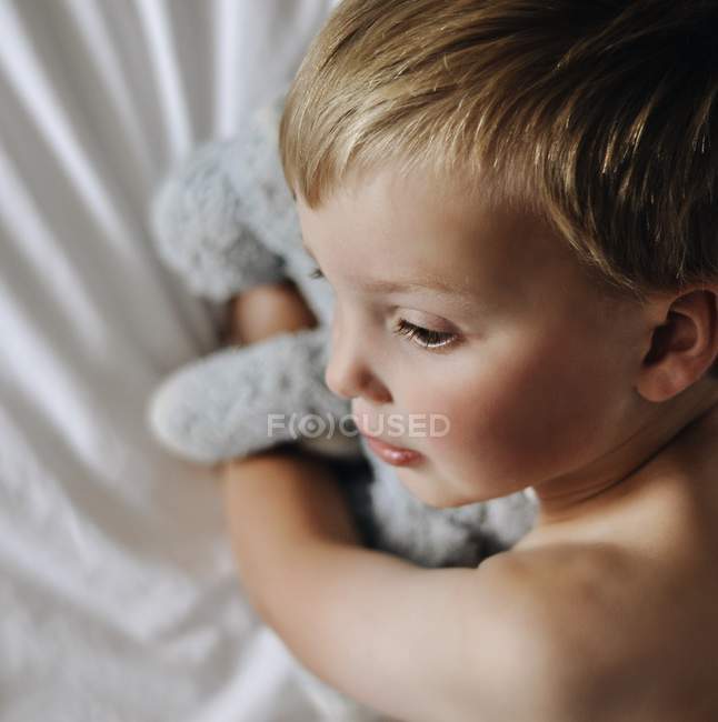 Хлопчик обіймає фаршировану іграшку — стокове фото