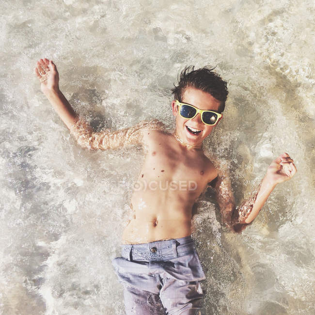 Boy lying in shallow sea — Stock Photo