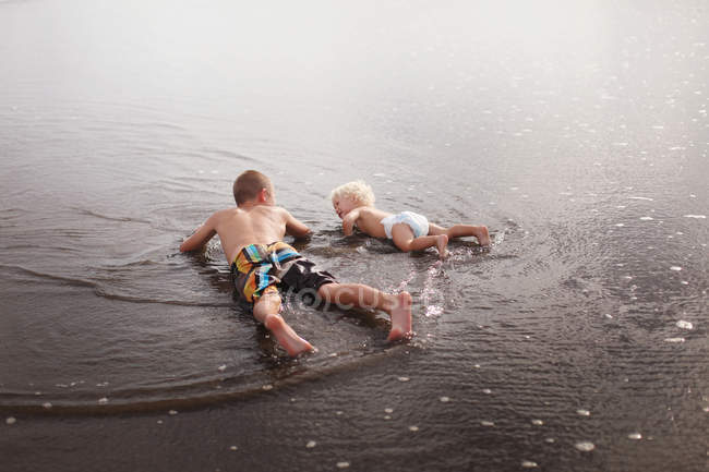 Fratelli sdraiati in acqua — Foto stock