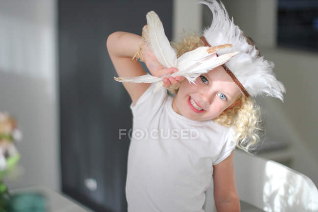 Girl wearing feather headdress — Stock Photo