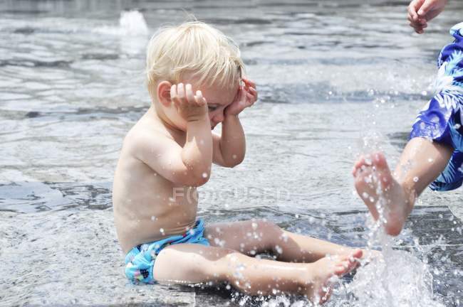 Boys playing in water fountain — Stock Photo