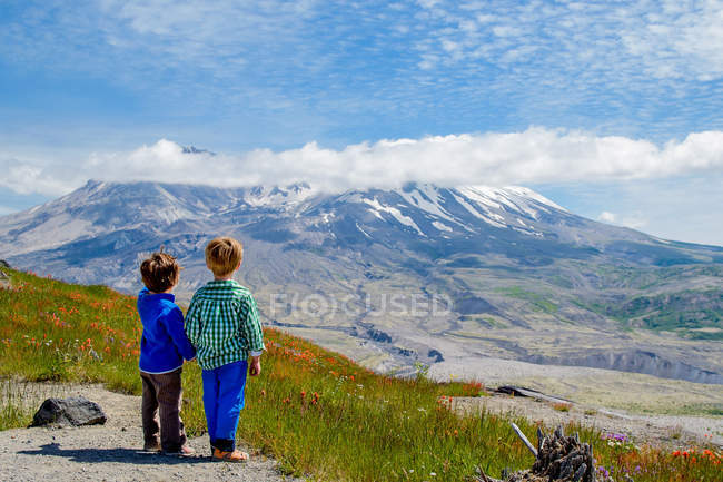Dos chicos mirando la vista de la montaña - foto de stock