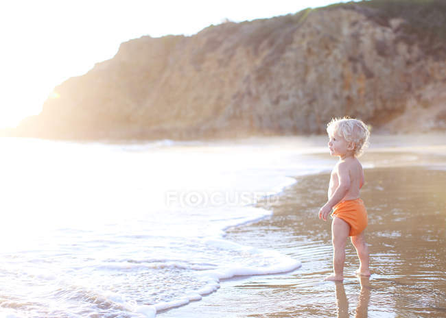 Тоддлер стоїть на пляжі — стокове фото