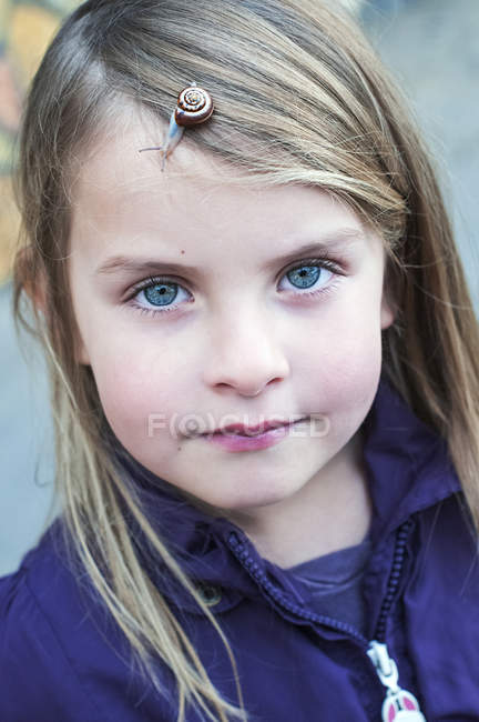 Little girl with snail on face — Stock Photo