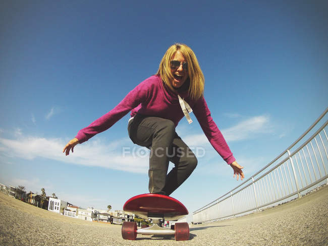 Молодая женщина на скейтборде — стоковое фото