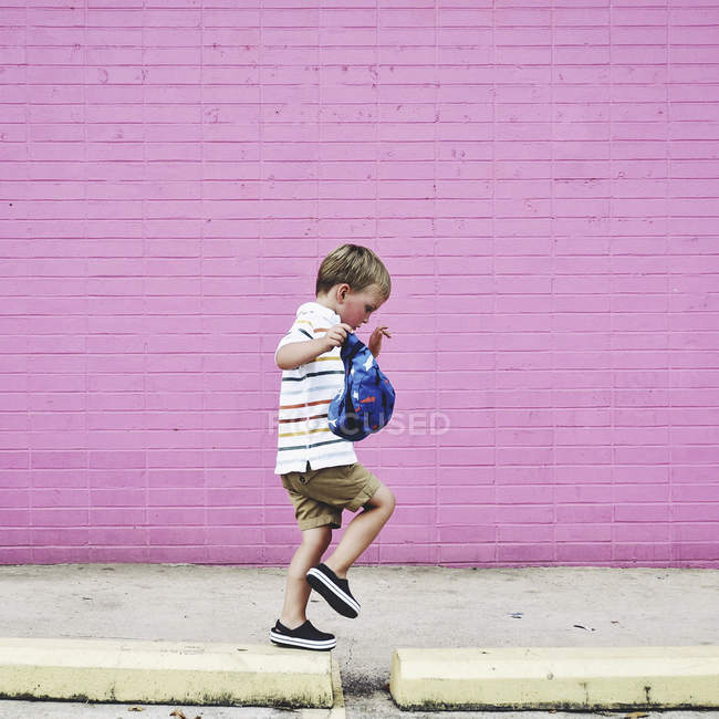 Little boy walking on sidewalk — Stock Photo