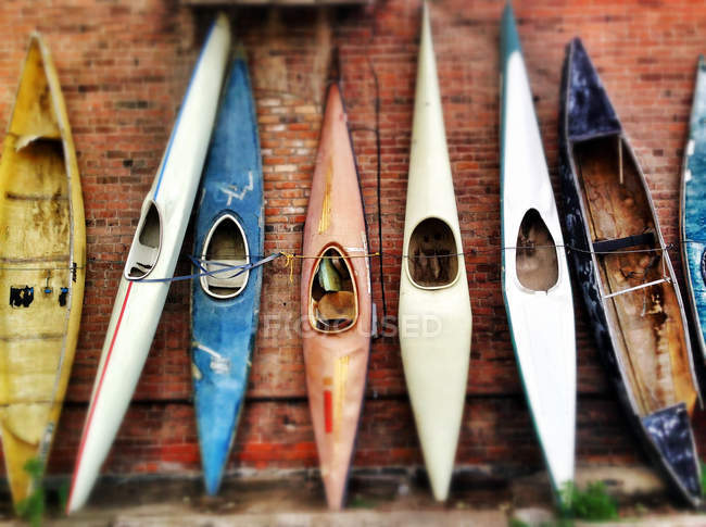 Row of canoes against wall — Stock Photo