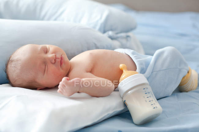 Niño recién nacido durmiendo después de la leche - foto de stock