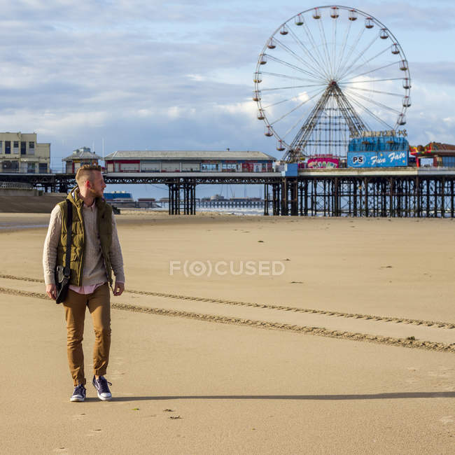 Человек на пляже и колесо обозрения — стоковое фото