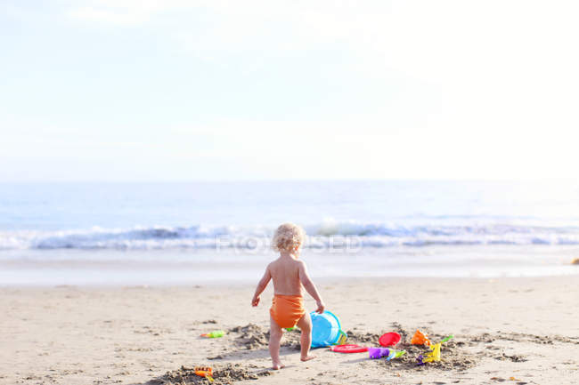 Entzückendes Kleinkind spielt am Strand — Stockfoto