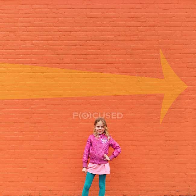 Girl standing in front of wall — Stock Photo