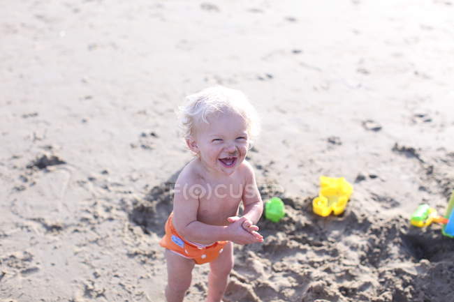 Toddler laughing on beach — Stock Photo