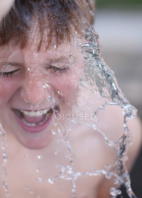 Acqua schizzi su ragazzo faccia — Foto stock