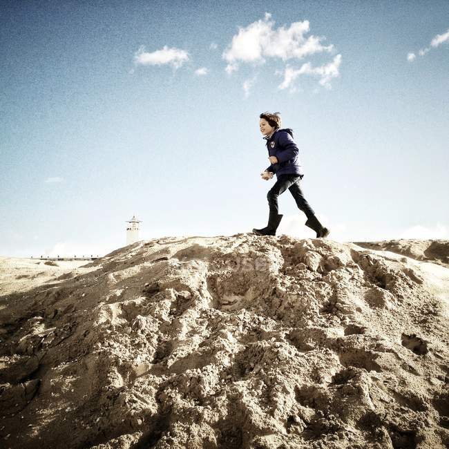 Хлопчик біжить на піщаній дюні — стокове фото