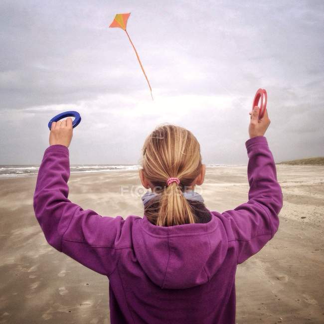 Mädchen fliegt Drachen am Strand — Stockfoto