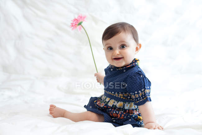 Bébé fille jouer avec fleur — Photo de stock
