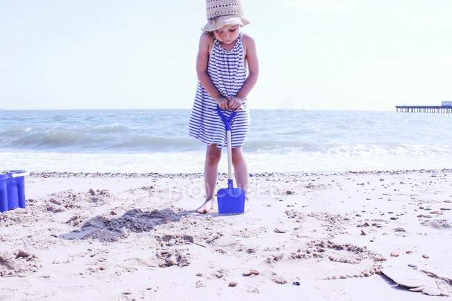 Ragazza con secchio e vanga sulla spiaggia — Foto stock