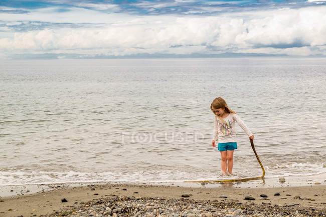 Дівчинка стоїть на пляжі — стокове фото