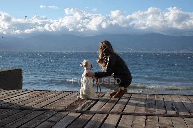 Жінка біля моря з собакою — стокове фото