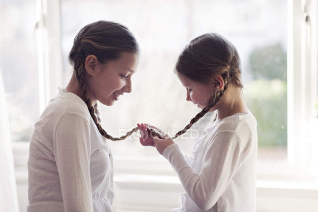Girls with plaits tied together — Stock Photo