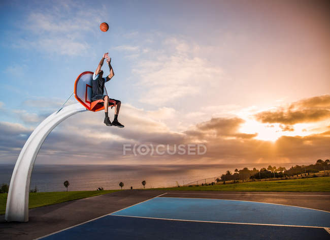 Людина сидить у баскетбольне кільце — стокове фото