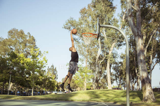 Hombre disparando aros de baloncesto - foto de stock