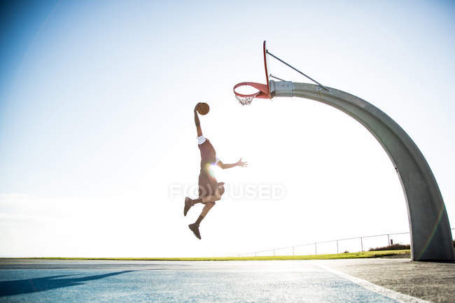 Мужчина играет в баскетбол в парке — стоковое фото
