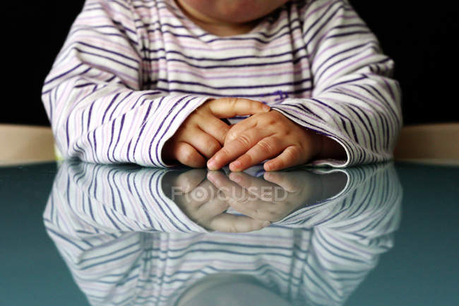 Bebê sentado à mesa com reflexão — Fotografia de Stock