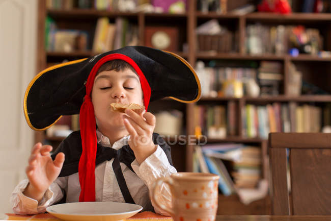 Молодий хлопчик їсть бутерброд вдома — стокове фото