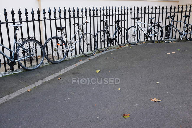 Bicicletas estacionadas a lo largo de la valla - foto de stock