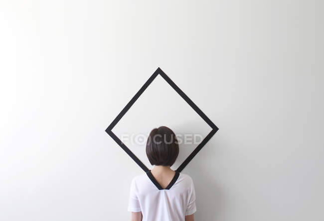 Mujer conceptual camuflada contra la pared - foto de stock