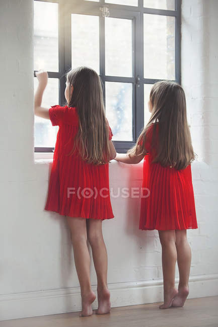 Meninas olhando pela janela — Fotografia de Stock
